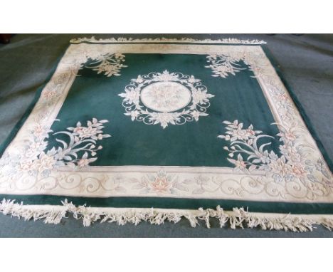 A SUPER WASHED AND HAND KNOTTED EMBOSSED CHINESE ALL WOOL CARPET with plain dark green field and cream and pastel coloured fl