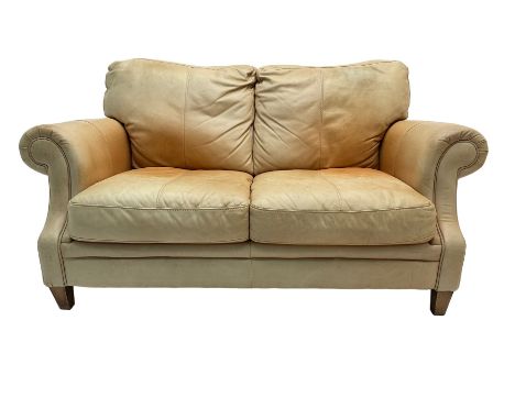 Two seat sofa, upholstered in pale tan leather with scrolled armsDimensions: Height:&nbsp;83cm&nbsp; Length/Width:&nbsp;150cm