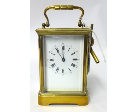 A carriage clock in brass case, 18cm (handle up) with striking movement and platform escapement, the dial with Roman numeral'