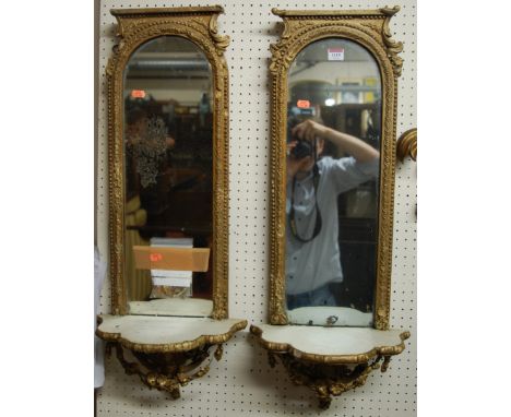 A pair of 19th century gilt wood marginal wall mirrors of arched form, each with shaped integral lower shelf