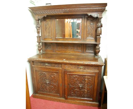A late 19th century heavily carved oak mirror back sideboard, the upper section with columns part carved depicting Continenta