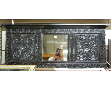An antique carved and ebonised oak overmantel mirror (converted coffer panel) width 112cm