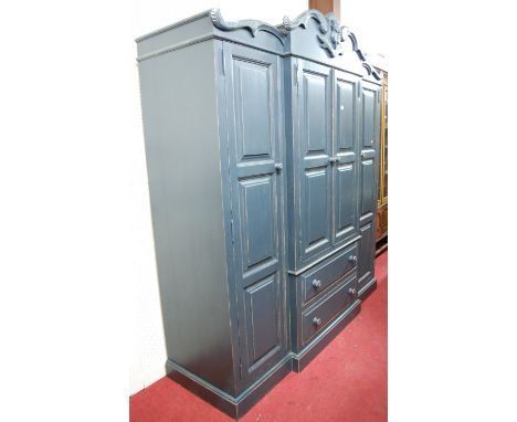 A modern blue painted pine breakfront wardrobe in the Victorian style, having recessed panel doors with two central long lowe