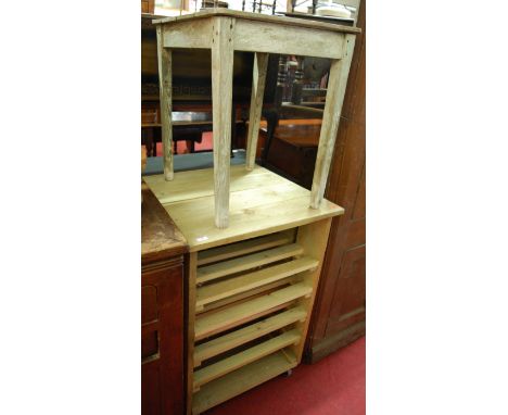 A reclaimed pine fruit tray trolley raised on roller castors; together with a rustic pine occasional table (2) 