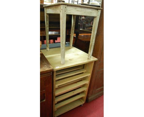 A reclaimed pine fruit tray trolley raised on roller castors; together with a rustic pine occasional table (2) 