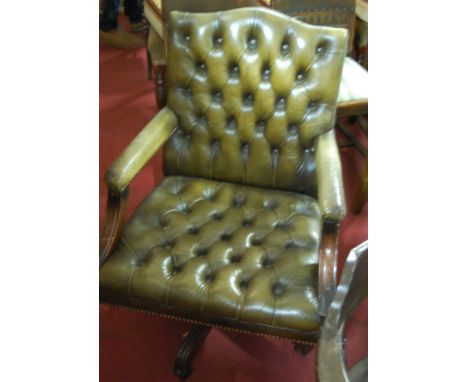 A reproduction mahogany green leather button back and further studded revolving desk chair
