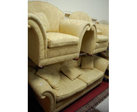 A Victorian style yellow floral upholstered three piece suite comprising; three seater sofa and a pair of armchairs, each on 