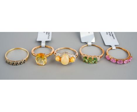 Five modern 9ct gem set dress rings, three with shop labels attached, including a Dourada fire opal, UK ring size K, a Paraib