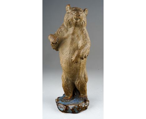 A 20th century Japanese pottery figure of a bear standing on hind legs, bisque with glazed base, impressed mark, height 24cm