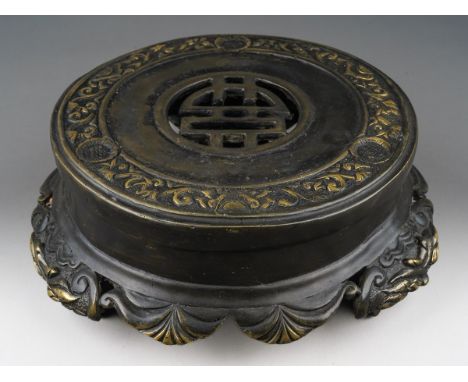 A Chinese bronze stand, the top cast with a band of shallow relief scrolls and foliate decoration, the centre pierced, the ap
