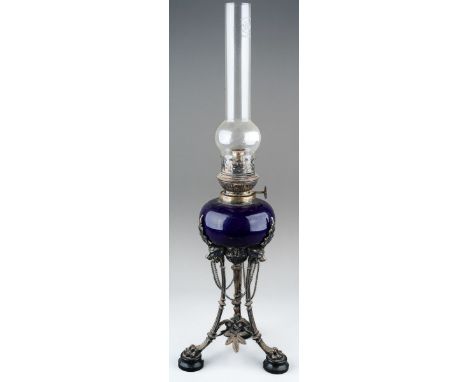 A Neo-Classical silver plated oil lamp, with blue glazed ceramic reservoir, on monopodia base, with chimney, no shade, height