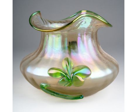 An early 20th century Loetz style iridescent glass vase of squat ribbed form, green rim and applied sinuous green fleur-de-ly