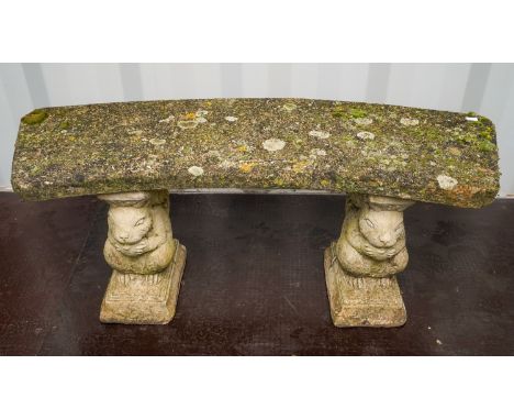 A reconstituted concrete garden bench, bowed seat on squirrel plinths, length 110cm x height 42.5cm, s.d.