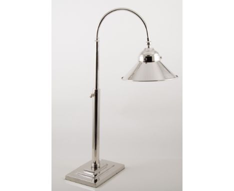 A modern nickel-plated desk lamp in the Art Deco style, the circular steel shade on curved arm 59cm high supported on a stepp