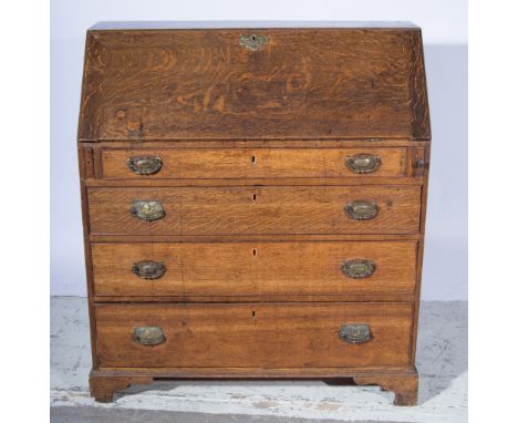 George III oak bureau, fall front enclosing an interior fitted with drawers, pigeon holes and a cupboard, with four long grad