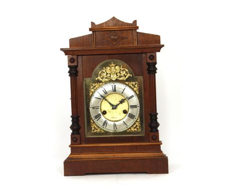 An early 20th century mantle clock, the brass and silvered face with Roman numerals, the German movement striking on a gong, 