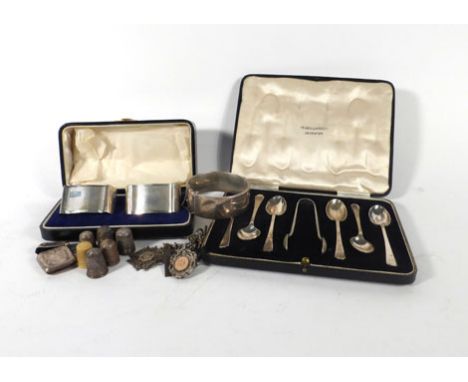 A cased pair of early 20th century silver engine turned napkin rings, a cased set of six silver teaspoons and matching nips, 