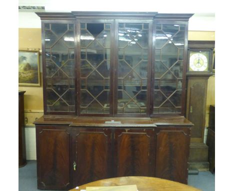 An early 20th century mahogany break front bookcase cabinet by Spillman & Co. of London, the four glazed doors enclosing late