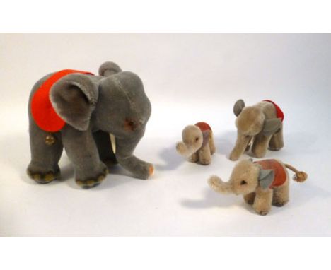 A Steiff grey mohair elephant with painted features and wearing a red felt band suspending two bells, button and yellow label