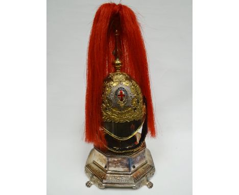 A half-size Life Guards helmet with plumage on white metal hinged plinth 