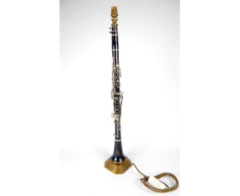 Boosey & Hawkes, an early 20th C bakelite clarinet, with later lamp conversion and raised on a stepped brass base, 75cm h