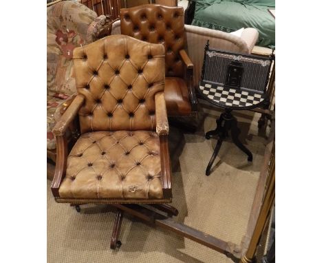Two modern leather button back swivel chairs, together with a decorative occasional table with chequered top and partition sc