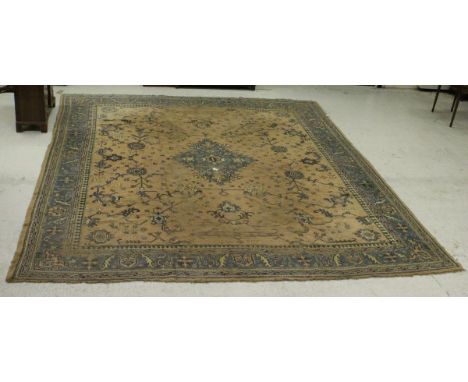 A Caucasian carpet, the central panel set with a floral decorated medallion on a fawn ground decorated with stylised floral s