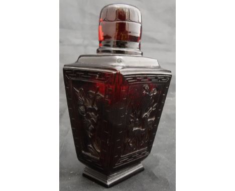 A 19th Century Chinese ruby amber scent bottle of tapering faceted rectangular form, the cylindrical top with carved decorati