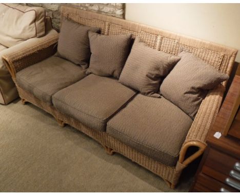 A modern rattan three seat conservatory sofa with brown and fawn upholstery