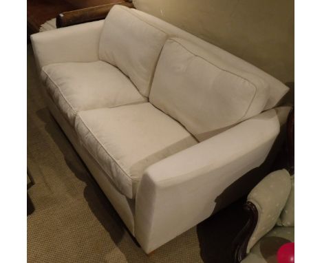 A modern Wesley Barrell two seat sofa with cream upholstery, together with two wicker tub chairs and a metal standard lamp