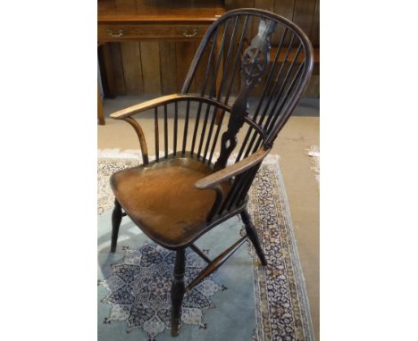 A 19th Century Windsor wheel and stick back chair on turned legs united by an H stretcher (with damage and agricultural repai