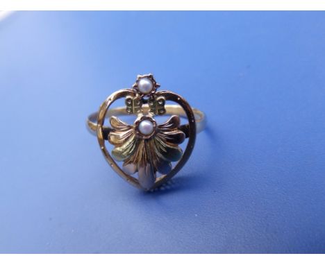 An antique two colour gold anthemion ring of openwork design set with two small pearls.  Finger size N.