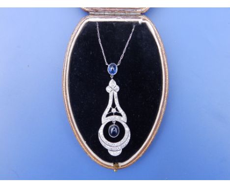 An art deco sapphire &amp; diamond set pendant necklace, of openwork design, having two cabochon sapphires and numerous mille
