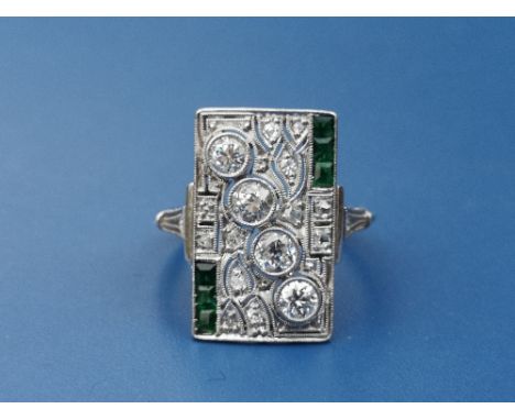 An art deco emerald &amp; diamond set panel ring, of rectangular openwork form, millegrain set with a diagonal line of four d