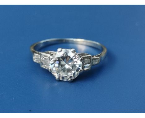 An art deco diamond solitaire ring, the claw set brilliant weighing approximately 1.2 carats, six small rectangular diamonds 