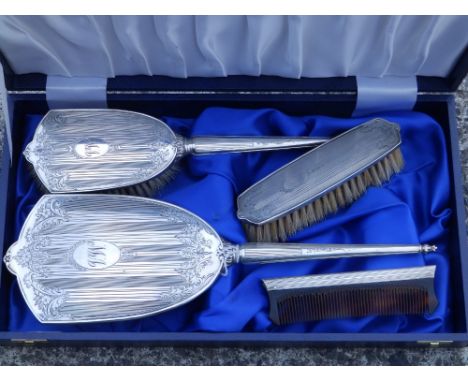 A modern cased silver dressing table brush set.