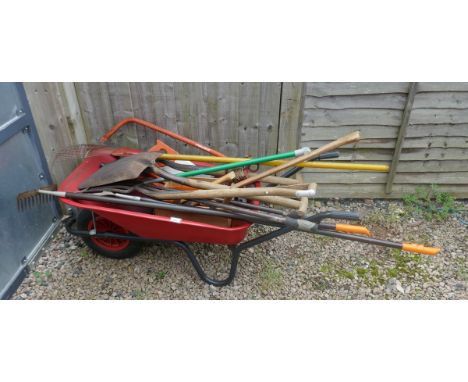 Large collection of gardening tools together with a wheelbarrow