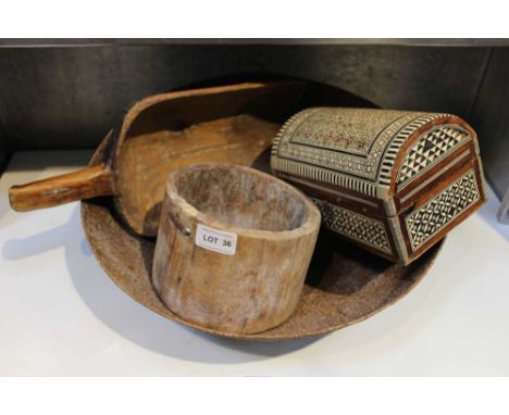 A metal bowl containing a dome topped casket and two grain scoops