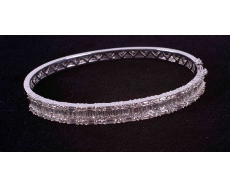 An 18ct white gold bangle set with approx. 4.45 carats of baguette cut &amp; round brilliant cut diamonds, colour H-I and SI2
