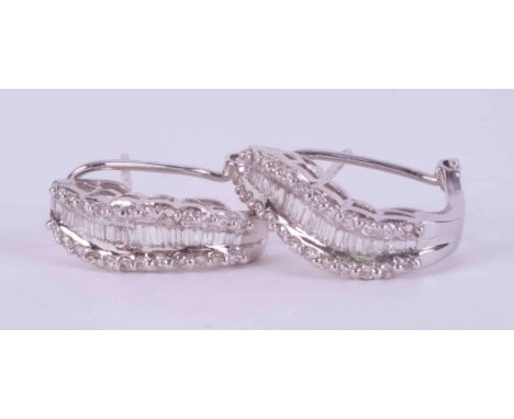 A pair of 18ct white gold wave design earrings set with approx. 1.34 carats total weight of baguette cut &amp; round brillian