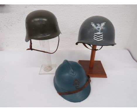 Three Various Steel Helmets consisting WW2 French example.  Repainted light blue.  Front flaming grenade badge.  Leather 7 to