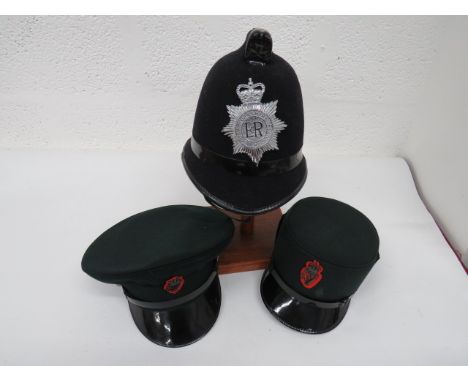 Three Various Police Hats consisting blue baize covered comb example helmet.  Blackened comb front mount.  QC chrome South Yo
