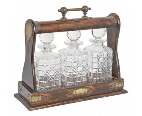 An EPNS mounted stained oak tantalus, mid 20th c, 29cm h excluding handle  Plating heavily rubbed, all three decanters with m