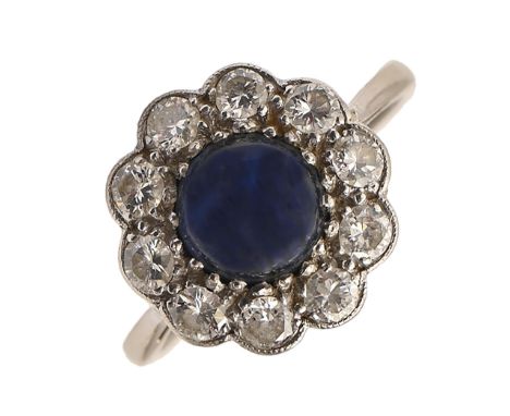 A sapphire and diamond ring, the larger central sapphire en cabochon, in platinum, head 14mm diam, 4.8g, size O  Sapphire fre