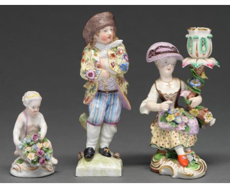 A Derby candlestick figure of a girl, c1830,&nbsp; seated on a mound and encrusted with flowers on scrolling gilt base, 13.5c