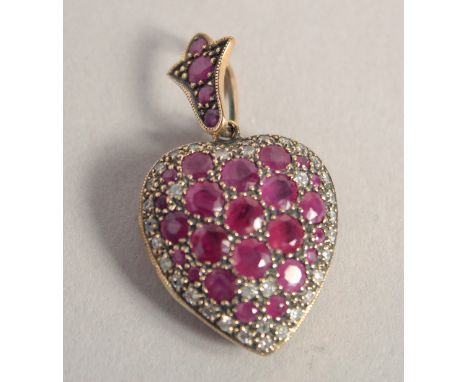 A 9CT GOLD RUBY AND DIAMOND HEART SHAPED LOCKET.