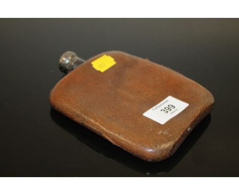 A WHITE METAL LEATHER COVERED HIP FLASK