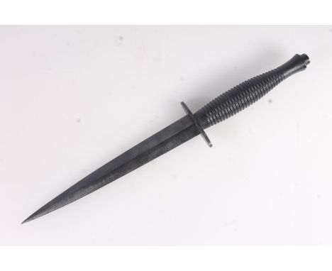British post WWII Fairbairn Sykes FS Commando dagger of typical form having blackened steel blade and grip, with scabbard and