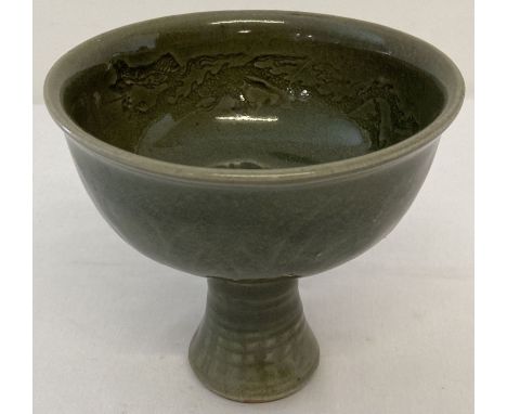 A Chinese porcelain celadon glazed stemmed bowl. Inner bowl is decorated with impressed design of fish, surrounded by a borde