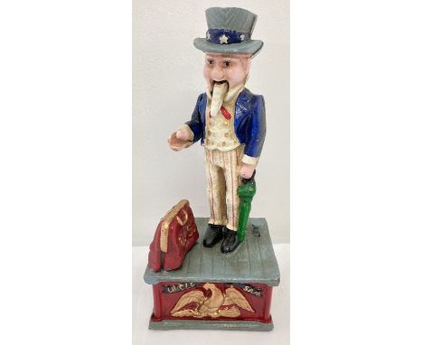 A painted cast iron mechanical "Uncle Sam" money box, with push button action. Arm moves to drop the coin into the opening ba